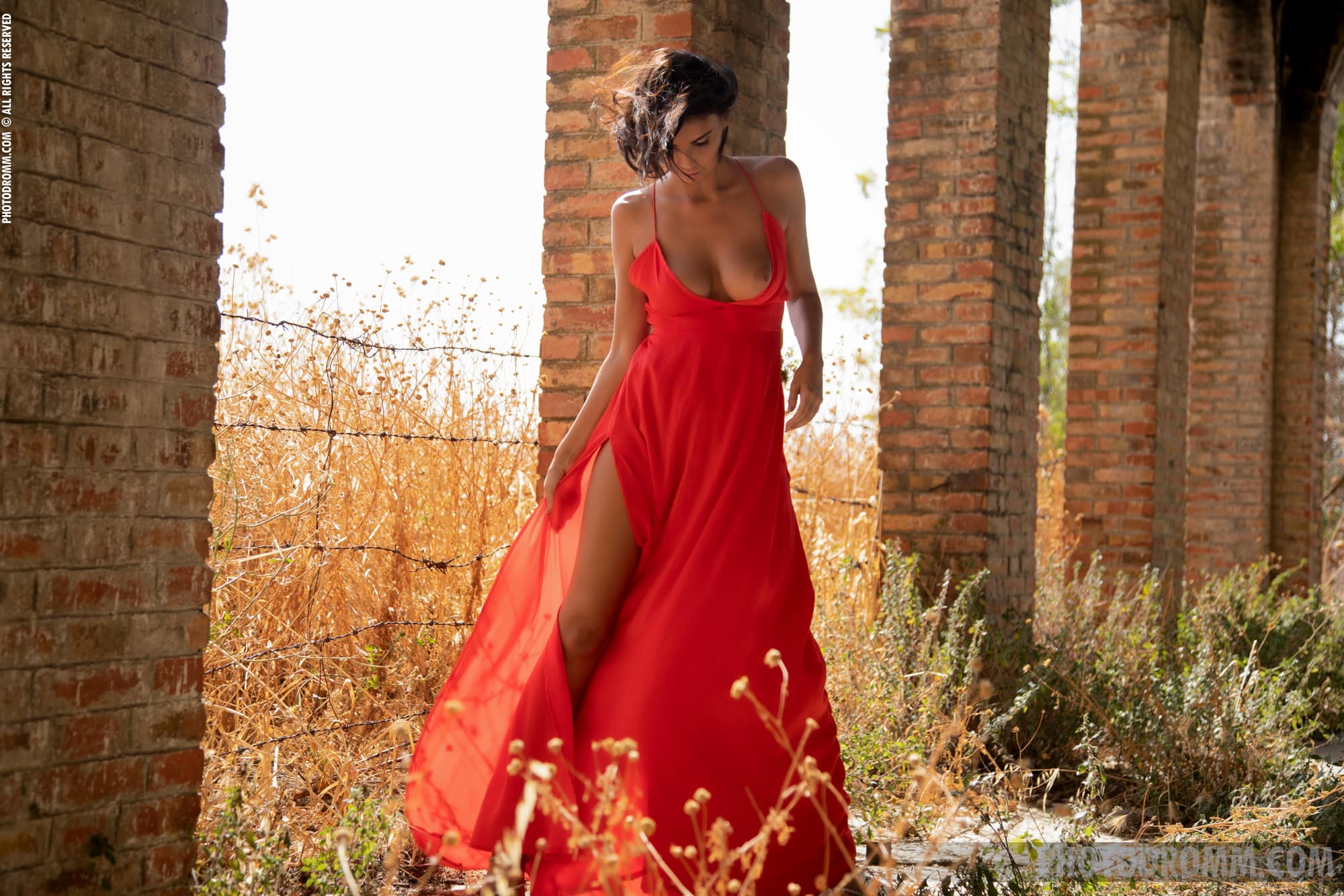 Giselle poses seductively as she slowly removes her red dress outdroors