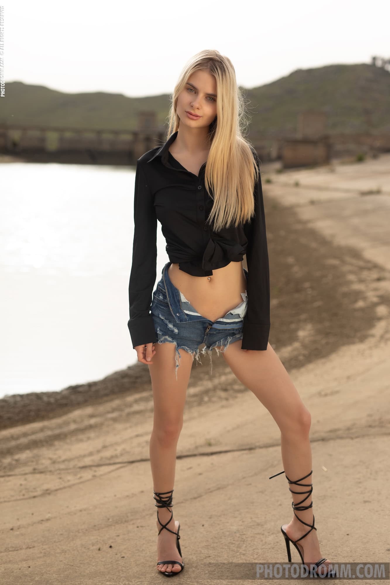 Briana drops jeans shorts, exhibiting her thin frame and big real tits in a field