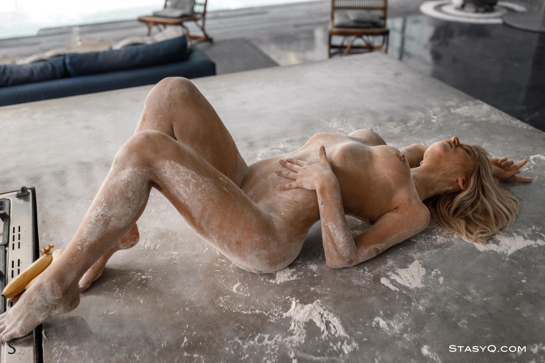 JennyQ covering her perfect nude body in flower on the kitchen counter